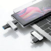 A black smartphone and a metal USB flash drive are shown on a white surface.