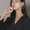 A woman is using a portable mini blade-less electric fan to cool her face.