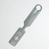 A silver durable PVC luggage tag with a loop for attachment and the text HAPPY FLIGHT TO YOUR DREAM CITY.
