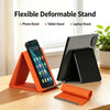 Orange silicone multi-angle stand holding a smartphone, tablet, and laptop in an office setting.