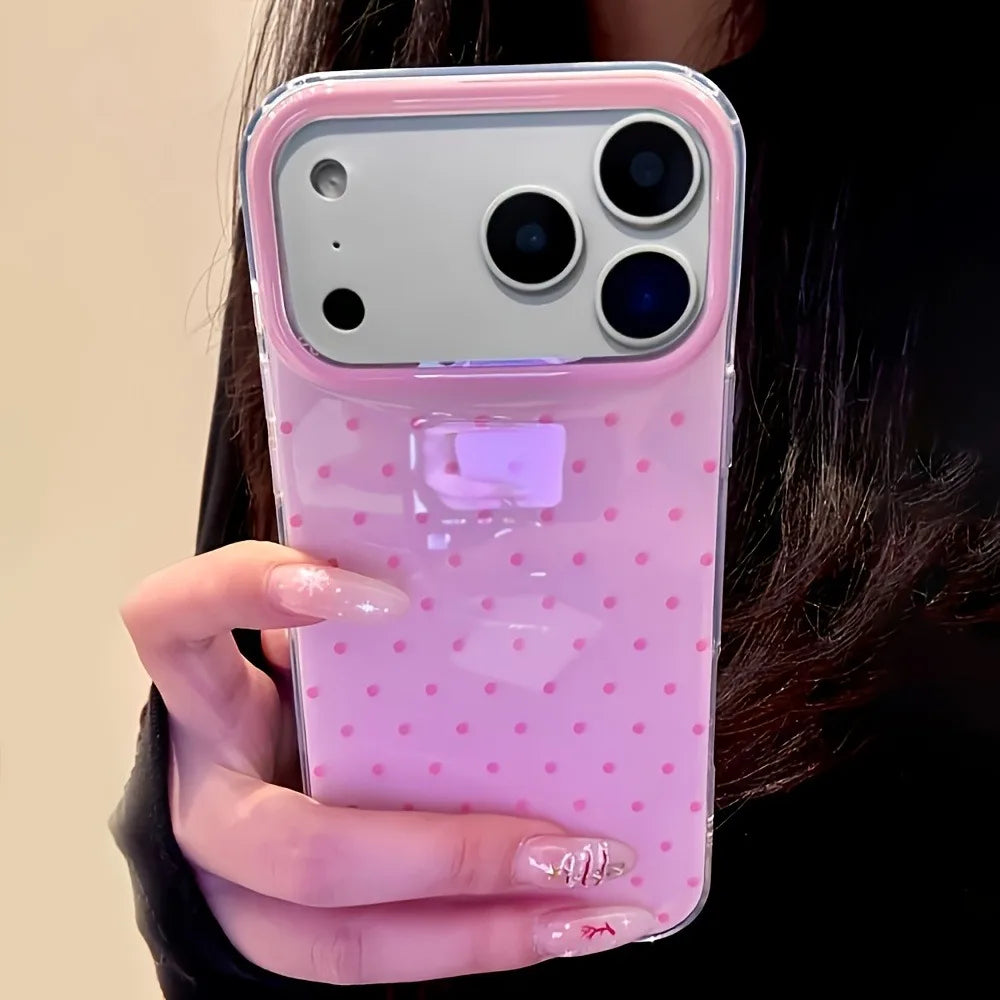 A hand holds a pink polka dot shockproof phone case with a purple accent on a smartphone.