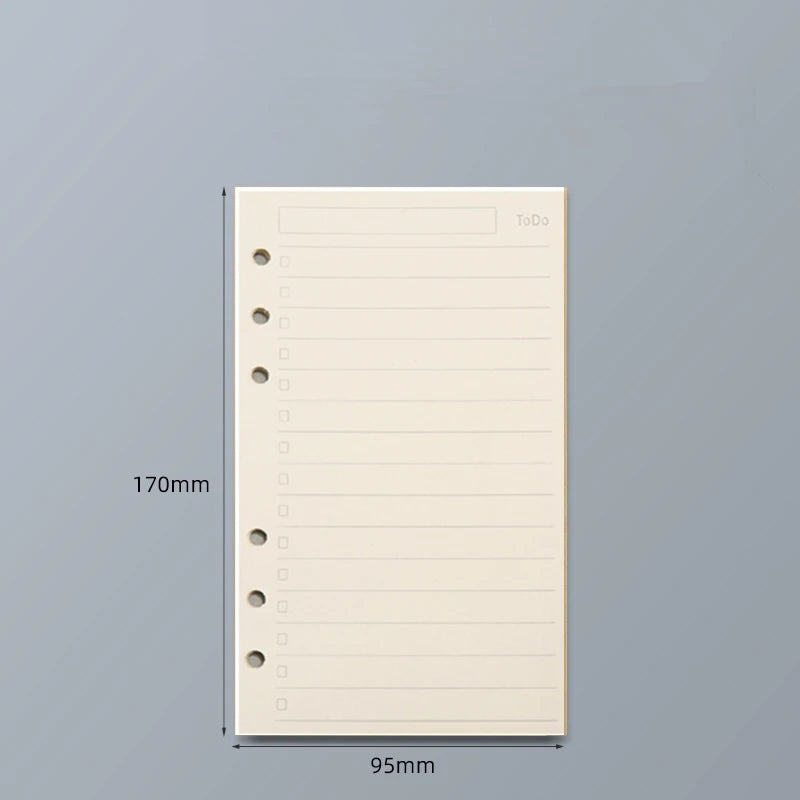 Cuaderno suelto de hojas claras beige con líneas rayadas y encabezado de lista de tareas, mostrado contra un fondo gris.