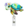 A colorful, translucent turtle charm attached to a silver badge reel clip.