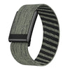 A close-up view of a black nylon braided strap for a watch, featuring a green and black striped pattern.
