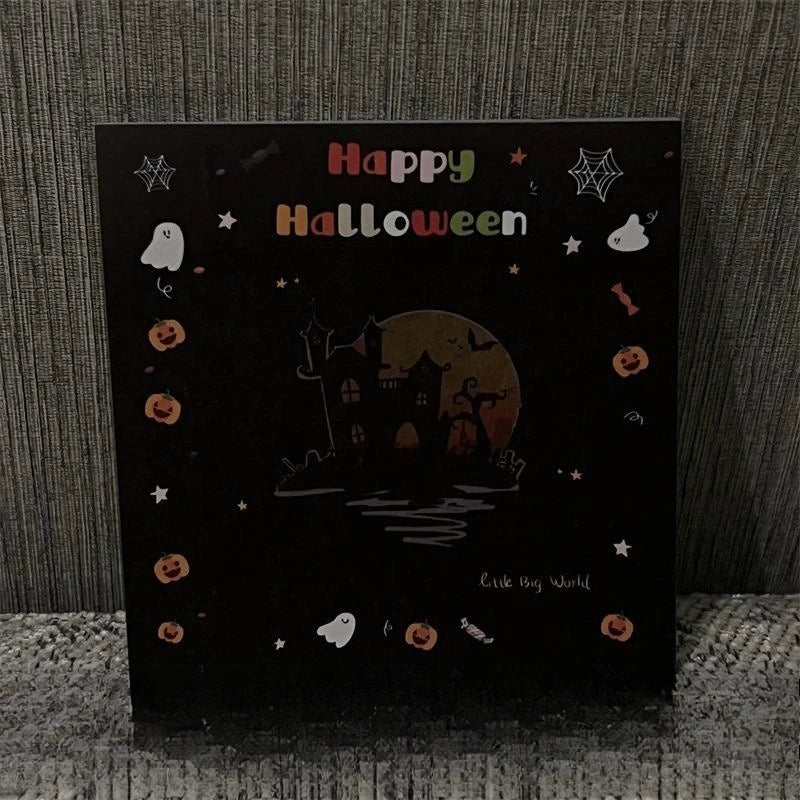 Schwarze Karte mit 'Happy Halloween' und Silhouette eines gruseligen Hauses vor orangem Mond.