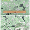Grüner Twill-Baumwollstoff mit Blumenmuster in Weiß und Schwarz.
