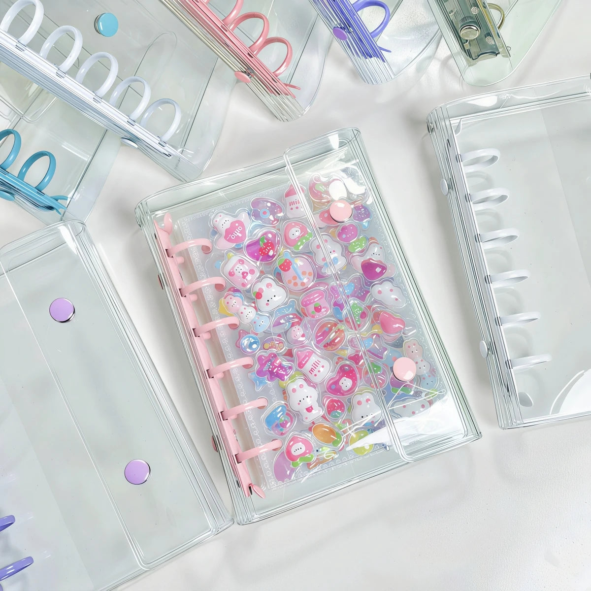 A collection of colorful double-button binders filled with various stickers and craft items.