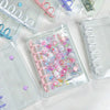 A collection of colorful double-button binders filled with various stickers and craft items.
