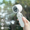 Eine Hand hält einen weißen tragbaren Handventilator, der starken Wind ausstößt und seine Funktionen demonstriert.