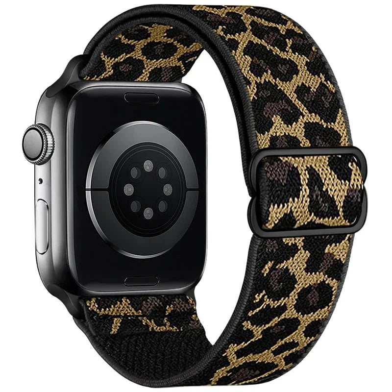 A black Apple Watch with a leopard print nylon band featuring gold and black patterns.
