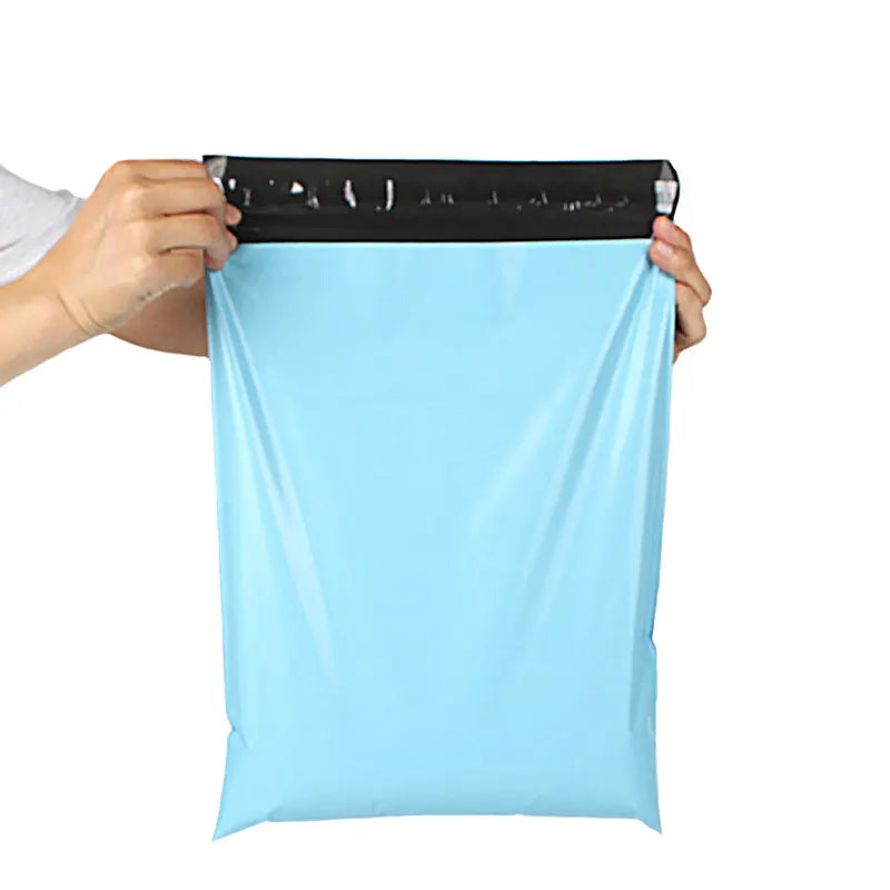 A hand is holding a light blue reusable waterproof poly shipping bag with a black seal.