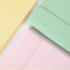 Three colored universal keyboard cases for an iPad, showing yellow, mint green, and pink options.