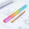 A colorful straight-edge geometric drawing cube is shown next to technical blueprints and rulers.