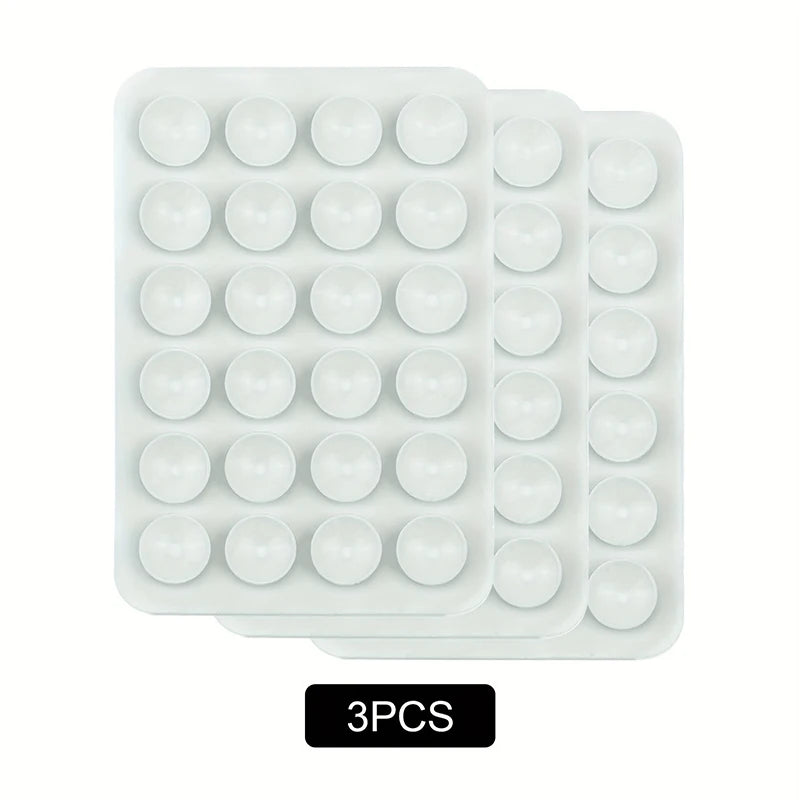 A pack of three white silicone suction phone mounts in a plastic tray.