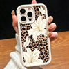 A hand holds a leopard print phone case with white lily floral designs for an iPhone.
