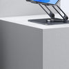 A silver tablet is displayed on a black rotating aluminum stand on a white surface.