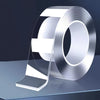 Roll of heavy duty double-sided nano adhesive tape shown on a glass surface.