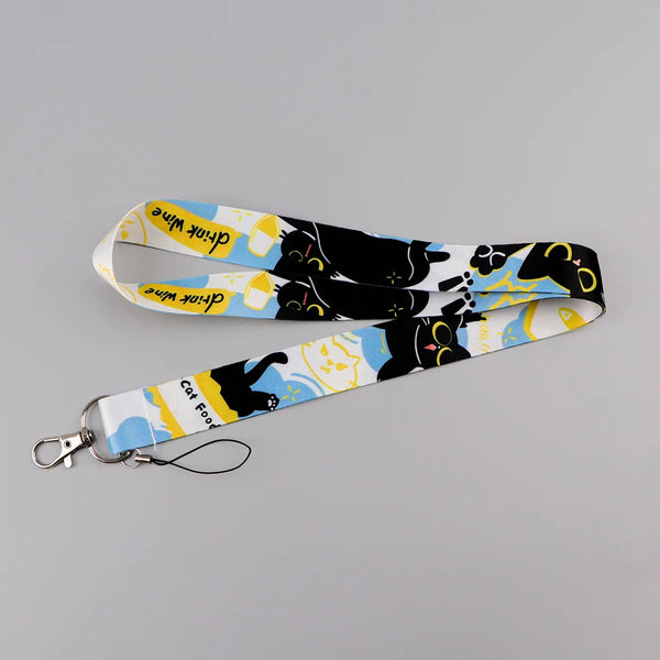 A yellow and white cat-themed lanyard with a card holder attached to a key ring.