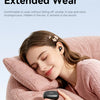 A woman is relaxing while holding a black Acer wireless clip-on earbud in her hand.