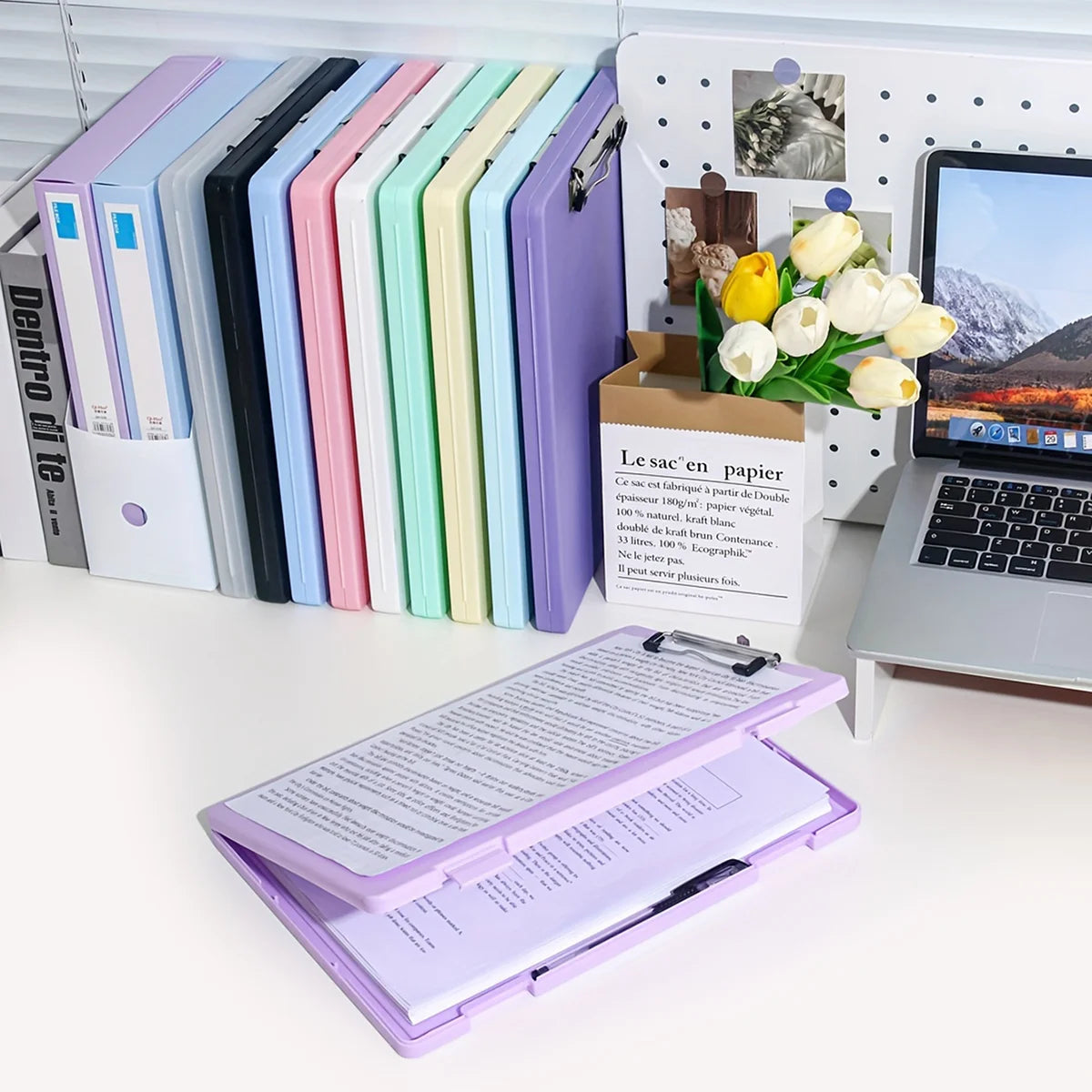 A set of colorful A4 document and photo storage file boxes lined up next to a laptop and a box of flowers.