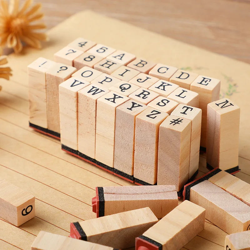 A collection of vintage wooden stamp seals arranged in a row, featuring letters and punctuation marks.