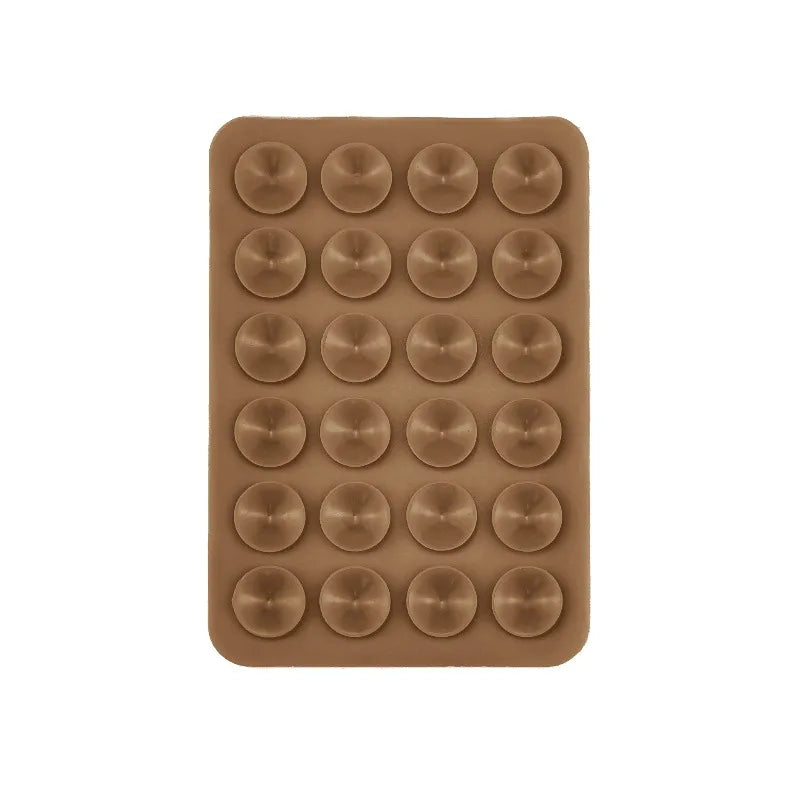 A brown silicone suction cup mount tray containing twenty-four circular suction cups for phone and tablet mounting.