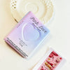 A pink heart-shaped photo card binder for Kpop albums resting on a white plate.