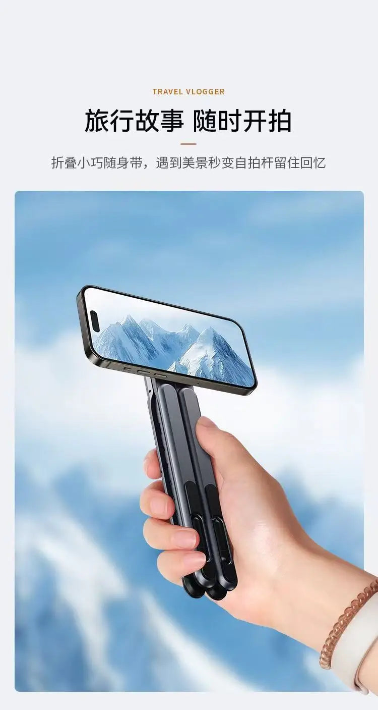 Eine Hand hält einen faltbaren Aluminium-Handyhalter, der eine bergige Landschaft auf einem Smartphone-Bildschirm zeigt.