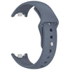 A gray silicone replacement strap for a Mi Band watch, shown in a curved form.