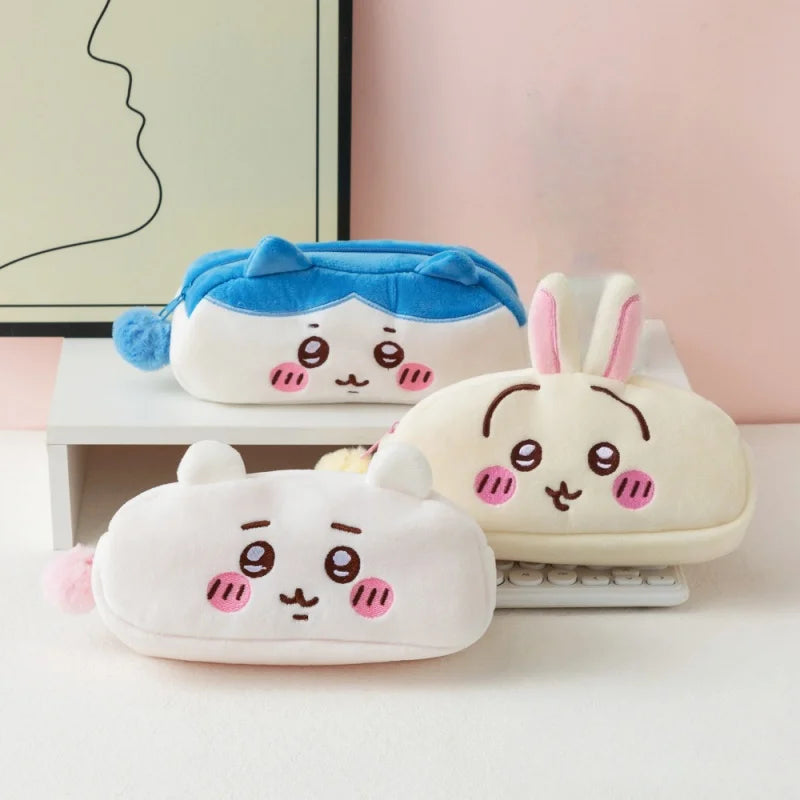 Three Chiikawa plush pencil cases in blue, white, and cream colors displayed on a light surface.