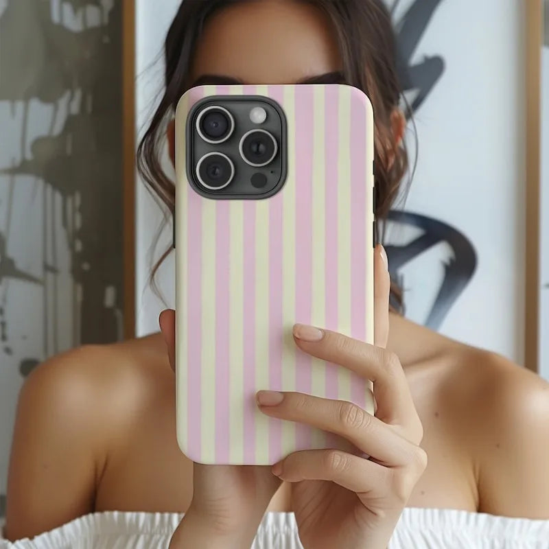 A hand holds a pink and yellow striped magnetic dual-layer phone case for an iPhone.