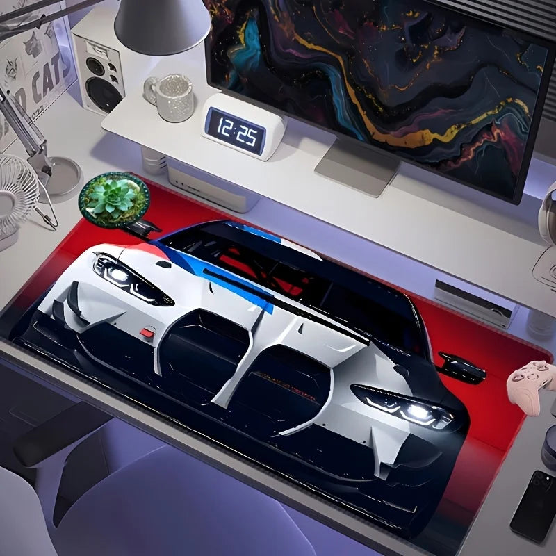 A large non-slip gaming mouse pad featuring a racing car design placed on a desk.