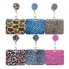 A collection of pink, blue, and leopard print retractable card holders with metal clips.
