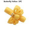 A yellow silicone butterfly pencil grip for children's handwriting aid.