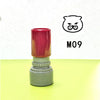 A red and gray teacher stamp with a cat face design is shown on a yellow surface.