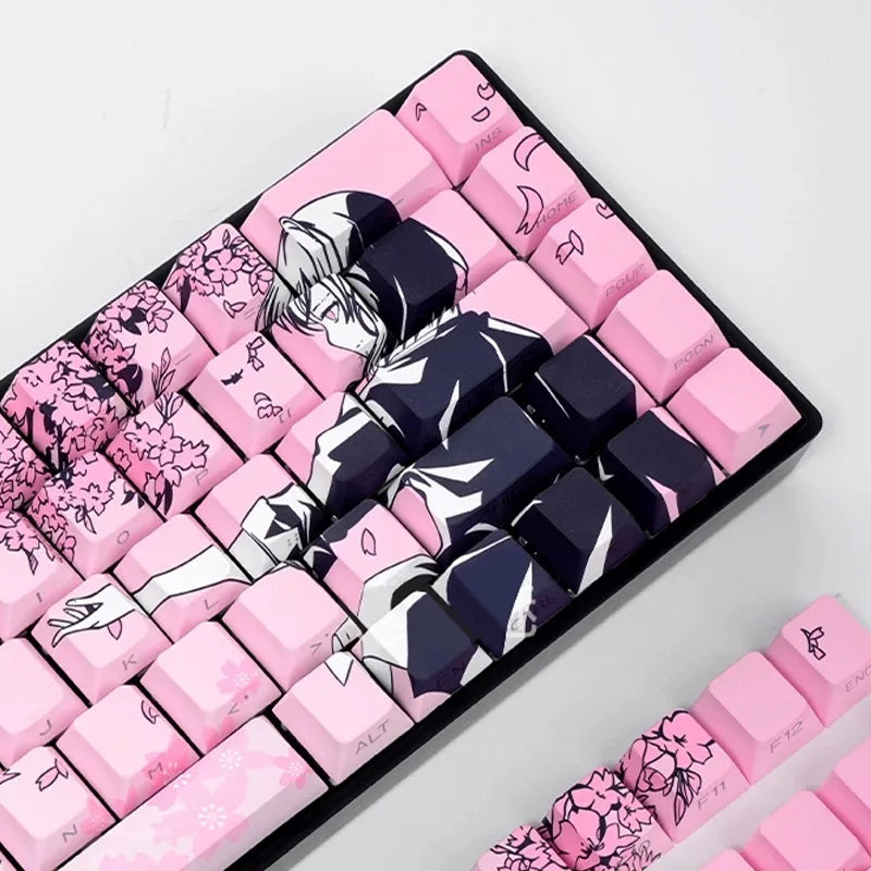 A close-up view of pink and dark purple Raven Sakura theme PBT mechanical keycaps arranged on a black keyboard tray.