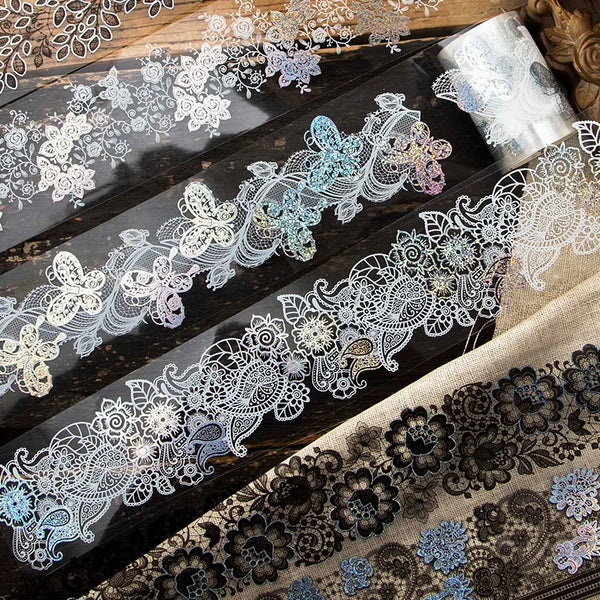Decorative silver stamping lace tape featuring floral patterns on a dark wooden surface.
