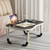 A laptop desk organizer tray with anti-slip table legs is shown on a light gray carpet.