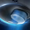 A close-up view of a silver wireless Bluetooth earbud with blue light effects against a dark, starry background.