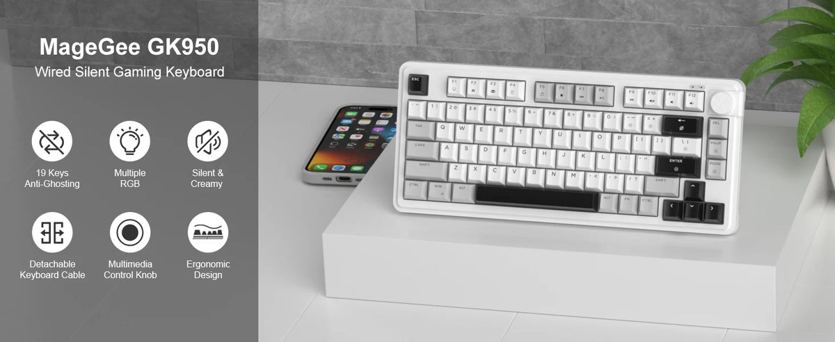 Teclado de juego silencioso MageGee GK950 blanco con cable, mostrado sobre una superficie blanca junto a un smartphone.