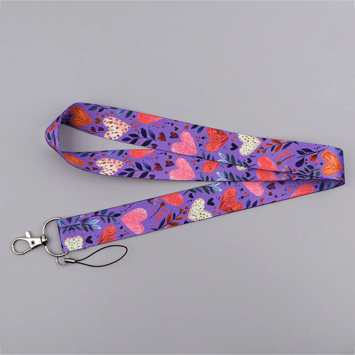 A purple floral heart-shaped lanyard featuring pink, orange, and white patterns for badges and keys.