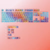A colorful rainbow shine PC keycap set for a mechanical keyboard displayed on a pink background.