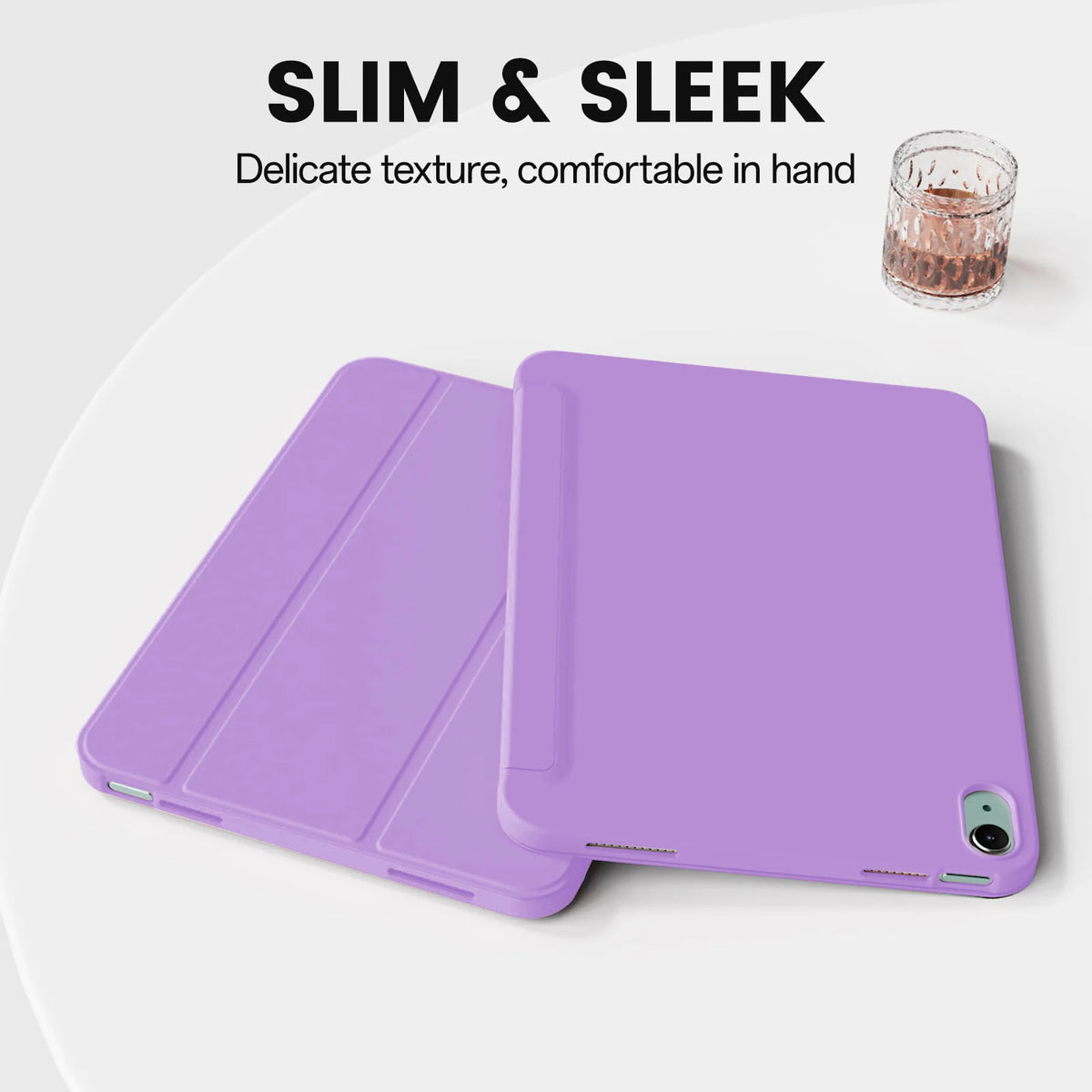 Una funda magnética plegable morada para iPad junto a un vaso de cristal.