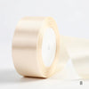 A roll of pale beige satin ribbon used for gift wrapping and DIY crafts.