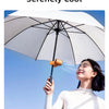 A woman is using a large white umbrella to create a cool breeze while holding a portable rechargeable cooling fan.