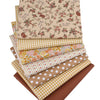 Gestapelte Twill-Baumwollstoffe mit Blumen- und Karomustern in Beige-, Gelb- und Brauntönen.