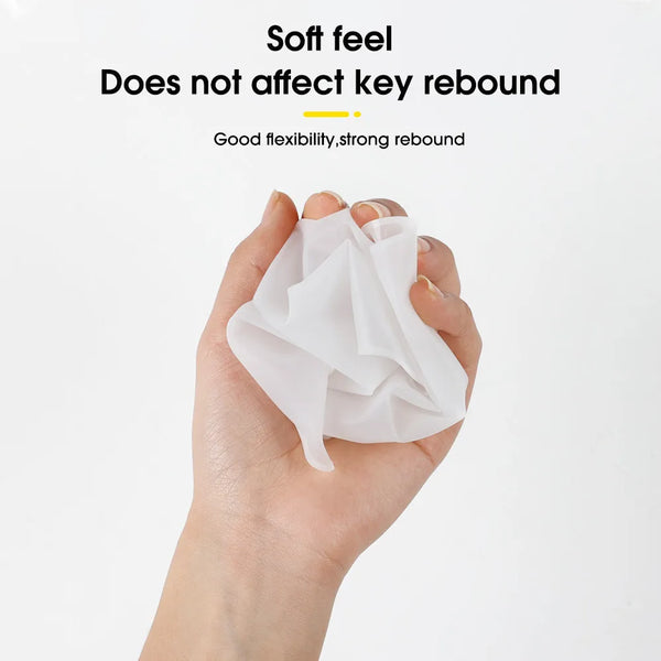 A hand is holding a crumpled white silicone laptop keyboard cover, demonstrating its soft feel and strong rebound.
