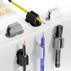 A collection of silicone self-adhesive pen holders in black and gray are displayed on a white surface.