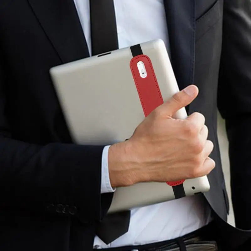 A person holds a silver tablet with a red protective case and stylus pen in a dark suit jacket.