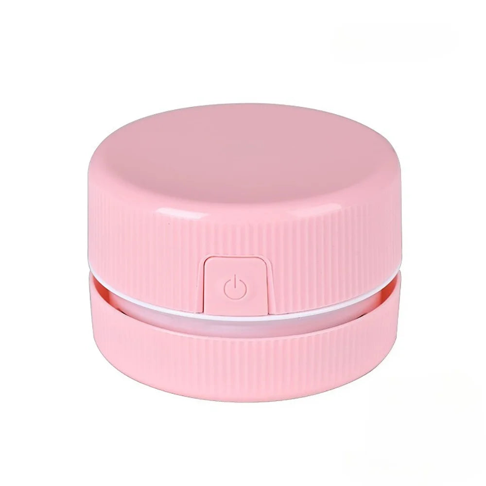 Pinker Mini-Schreibtischstaubsauger mit runder Abdeckung und Knopf.